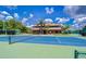 Exterior tennis court with a community building in the background provides an active lifestyle at 17032 Winners Cir, Odessa, FL 33556