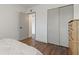 Bedroom with wood floors, closet with gray sliding doors, and an open doorway to an adjacent room at 2257 World Parkway W Blvd # 61, Clearwater, FL 33763