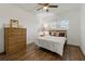 Cozy bedroom with wood floors, a ceiling fan, large dresser, and bright natural light from the window at 2257 World Parkway W Blvd # 61, Clearwater, FL 33763