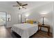 Bright bedroom featuring wood floors, a ceiling fan, and charming bedside tables with decorative lamps at 2257 World Parkway W Blvd # 61, Clearwater, FL 33763
