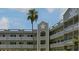 The condominium building features a well-kept exterior, a tropical palm tree, and a light gray color scheme at 2257 World Parkway W Blvd # 61, Clearwater, FL 33763