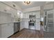 Well-lit kitchen offers modern white cabinets, stainless steel appliances, and wood-look floors at 2257 World Parkway W Blvd # 61, Clearwater, FL 33763