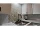 Kitchen featuring mosaic backsplash, black faucet, and modern sink at 2257 World Parkway W Blvd # 61, Clearwater, FL 33763