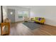 Bright living room features wood floors, gray door, modern sofa and chair, plus large windows at 2257 World Parkway W Blvd # 61, Clearwater, FL 33763