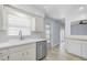 Cozy kitchen featuring white cabinetry, a stainless steel dishwasher, and tiled floors at 2813 21St W Ave, Bradenton, FL 34205
