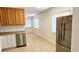 Kitchen view complete with stainless steel dishwasher and refrigerator along with tiled floors and a bright aesthetic at 530 74Th N Ave, St Petersburg, FL 33702