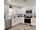 Modern kitchen with stainless steel appliances, white cabinetry, and ample counter space for meal preparation at 6320 Cedar St Ne, St Petersburg, FL 33702