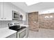 Modern kitchen with stainless steel appliances and a brick accent wall at 15609 Timberline Dr, Tampa, FL 33624
