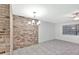 Cozy living room featuring tile floors, brick accent wall and ample natural light at 15609 Timberline Dr, Tampa, FL 33624
