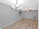 Bright living room features modern light fixture and attractive wood-look laminate flooring at 15609 Timberline Dr, Tampa, FL 33624