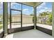A screened porch with a view of a backyard, featuring pavers and lush landscaping at 11314 Grand Park Ave, Riverview, FL 33578