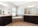 Bathroom featuring dual sinks, soaking tub, and large vanity mirrors at 11314 Grand Park Ave, Riverview, FL 33578