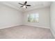 Spacious primary bedroom with a tray ceiling and a large window at 11314 Grand Park Ave, Riverview, FL 33578