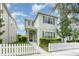 Two-story home with muted green exterior, complemented by a charming white picket fence and lush landscaping at 11314 Grand Park Ave, Riverview, FL 33578