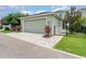 Attached two-car garage with light green exterior and a walkway to the front gate at 11314 Grand Park Ave, Riverview, FL 33578