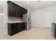 Modern kitchen featuring sleek stainless steel appliances, dark wood cabinets, and plenty of counter space at 11314 Grand Park Ave, Riverview, FL 33578