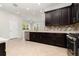 Well-equipped kitchen with dark wood cabinetry, stainless steel appliances, and an open view into the dining area at 11314 Grand Park Ave, Riverview, FL 33578