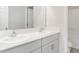 Bright double vanity bathroom featuring granite counter and white cabinets at 12829 Scarlet Star Dr, Riverview, FL 33579