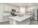 Modern kitchen boasts stainless steel appliances, gray cabinetry, quartz countertops, a kitchen island and recessed lighting at 12829 Scarlet Star Dr, Riverview, FL 33579