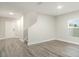 Open living room with neutral walls, gray wood floors, lots of natural light and stairway to the second floor at 12829 Scarlet Star Dr, Riverview, FL 33579