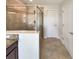Bathroom showcasing a glass-enclosed shower with decorative tile and a granite-topped vanity at 19491 Paddock View Dr, Tampa, FL 33647