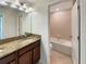 Bathroom featuring a granite-topped double vanity and an adjacent open doorway to the toilet and bathtub at 19491 Paddock View Dr, Tampa, FL 33647