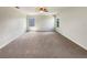 Spacious bedroom featuring neutral carpeting, a ceiling fan, and abundant natural light from two windows at 19491 Paddock View Dr, Tampa, FL 33647