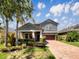 Charming two-story home with a well-maintained yard and a brick-paved driveway under a bright blue sky at 19491 Paddock View Dr, Tampa, FL 33647