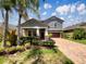 Charming two-story home with a well-maintained yard and a brick-paved driveway under a bright blue sky at 19491 Paddock View Dr, Tampa, FL 33647