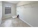 Functional laundry room with tile flooring, overhead shelving, and a window at 19491 Paddock View Dr, Tampa, FL 33647
