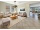 Bright living room featuring neutral furniture, tile floors, and natural light from multiple windows overlooking the yard at 19491 Paddock View Dr, Tampa, FL 33647