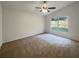 Spacious bedroom with carpeting, fan, and a large window providing natural light at 9855 Morris Glen Way, Temple Terrace, FL 33637