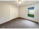 Bedroom featuring neutral carpeting, a window, and a closet with paneled doors at 9855 Morris Glen Way, Temple Terrace, FL 33637