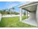 A covered patio overlooks the spacious backyard with lush grass and mature landscaping at 9955 Patrician Dr, New Port Richey, FL 34655