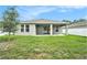 Home's backyard features a covered patio, lush lawn and a fenced yard for privacy at 9955 Patrician Dr, New Port Richey, FL 34655