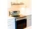 Contemporary stainless steel range stove with electric cooktop, set against white cabinetry at 14073 Naylor Ave, Port Charlotte, FL 33981