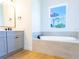 Bright bathroom featuring a modern tub under a window, a vanity, and a shower at 14073 Naylor Ave, Port Charlotte, FL 33981