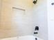 Modern bathroom featuring a tub with sleek fixtures and tiled walls with a built-in niche at 14073 Naylor Ave, Port Charlotte, FL 33981