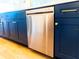 Sleek stainless steel dishwasher, surrounded by navy cabinetry and accented with brass hardware at 14073 Naylor Ave, Port Charlotte, FL 33981