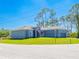 Low angle front view of a charming one-story gray house featuring a well-kept green lawn on a clear day at 14073 Naylor Ave, Port Charlotte, FL 33981