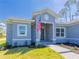 Close-up of the home's facade featuring a gray frame, an American flag, and well-maintained landscaping at 14073 Naylor Ave, Port Charlotte, FL 33981