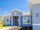 Detailed view of the entrance, featuring a gray frame, an American flag, and manicured landscaping at 14073 Naylor Ave, Port Charlotte, FL 33981