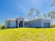 Charming single-story home with a well-manicured lawn, gray brick driveway, and an attached two-car garage at 14073 Naylor Ave, Port Charlotte, FL 33981