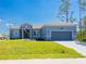Charming single-story home with a well-manicured lawn, gray brick driveway, and an attached two-car garage at 14073 Naylor Ave, Port Charlotte, FL 33981