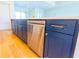 Kitchen island featuring navy cabinets, stainless steel appliances, gold hardware, and a built-in dishwasher at 14073 Naylor Ave, Port Charlotte, FL 33981
