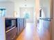Open concept kitchen with dark cabinets, stainless steel appliances, and a golden faucet under modern lighting at 14073 Naylor Ave, Port Charlotte, FL 33981