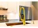 Modern kitchen with white cabinets, gold hardware, stainless steel appliances, and golden faucet at 14073 Naylor Ave, Port Charlotte, FL 33981