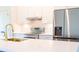 Bright kitchen showcasing white cabinets, stainless steel appliances, quartz countertops, and a gold faucet at 14073 Naylor Ave, Port Charlotte, FL 33981