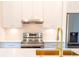 Kitchen featuring white cabinets, quartz countertops, stainless steel appliances, and a gold faucet at 14073 Naylor Ave, Port Charlotte, FL 33981