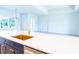 Kitchen island featuring quartz countertops, a gold faucet, and an open view to the living space at 14073 Naylor Ave, Port Charlotte, FL 33981